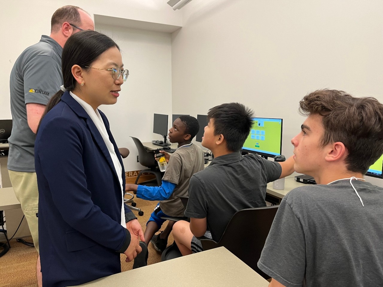 Teens intently talk to AI professionals while doing computer activities