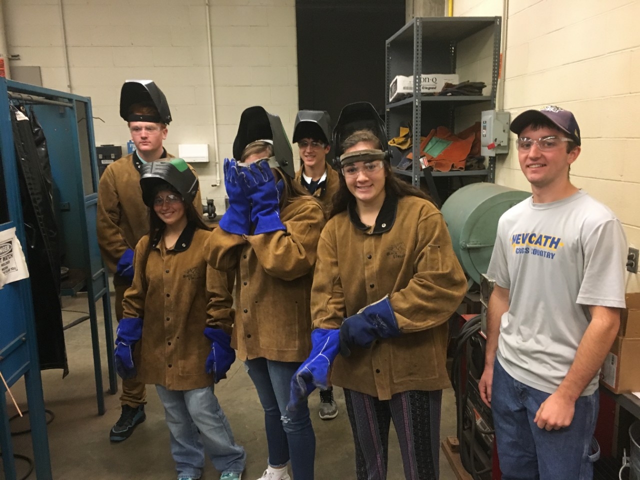 High school students smiling for the camera, dressed in safety gear at Engineering Career Day