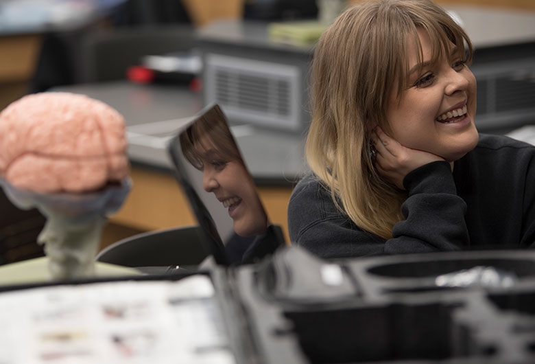 Student smiling inside of biology lab.