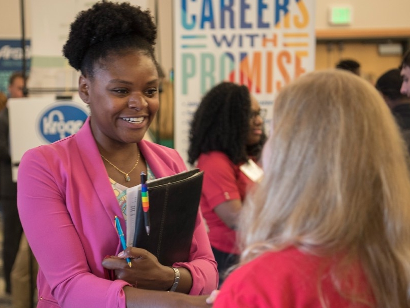 Student speaking with representative at career fair.