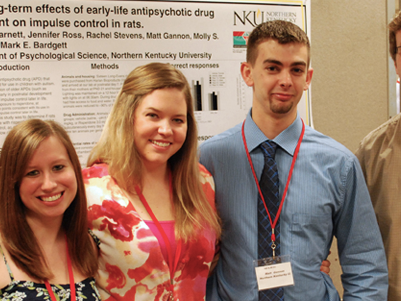 Student standing by research poster.