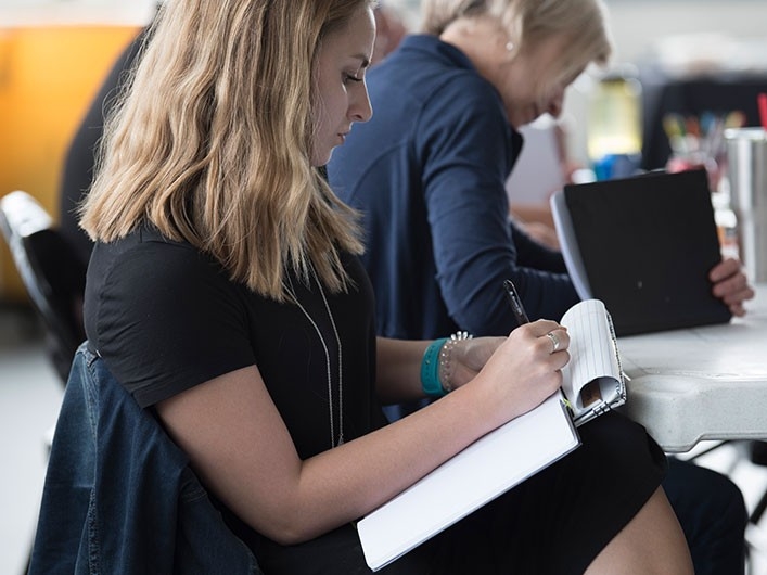 Young professional woman taking notes at a meeting