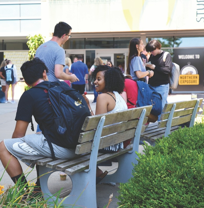 student hanging out under a tree