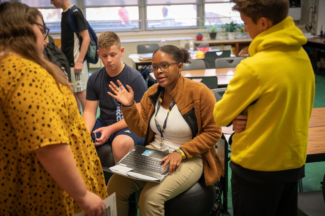 Students in classroom huddled in a group