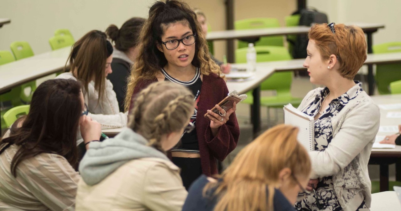 Students talking in a group inside classroom