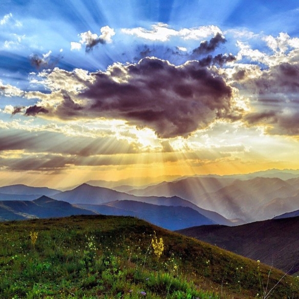 sunlit sky with clouds and colorful rays of sunshine 