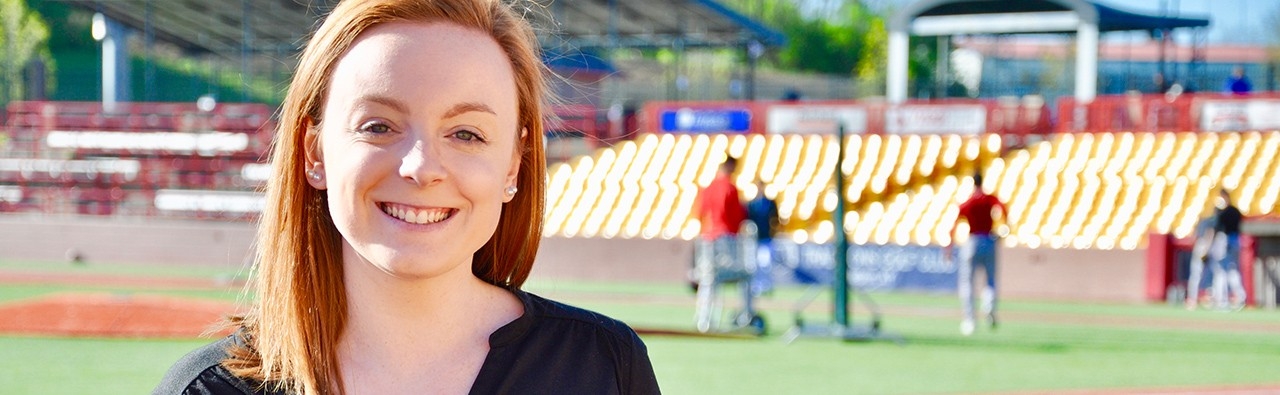 Young woman smiling inside of NKU baseball