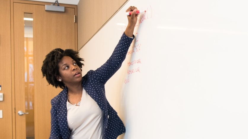 Teacher writing on white board