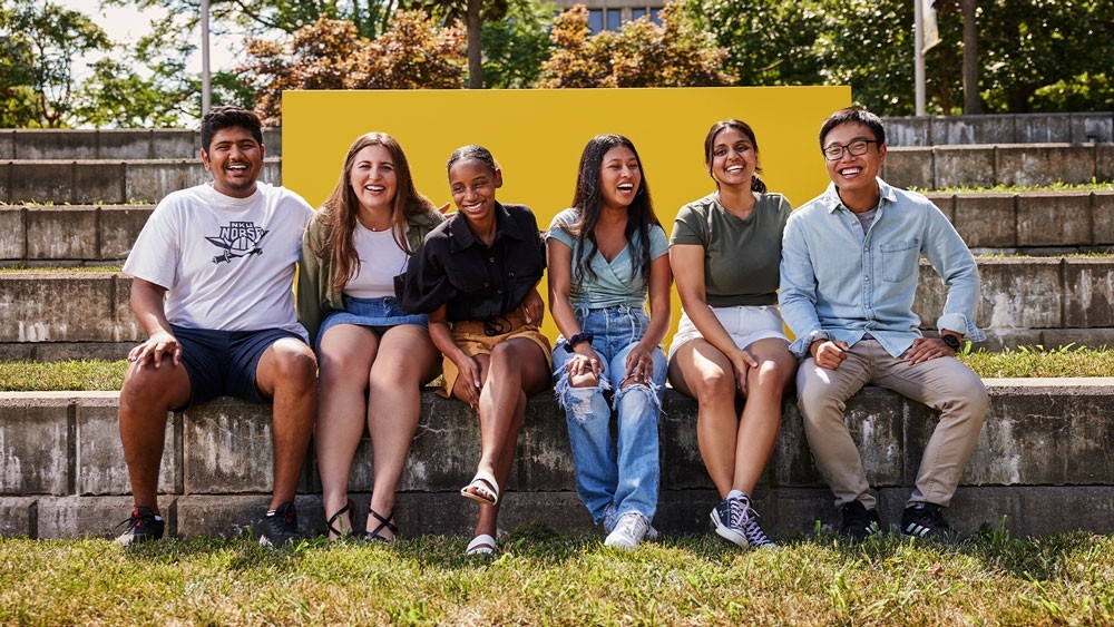 Group of students sitting outside and smiling