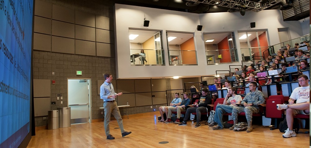 An NKU professor lectures in front of a group in the Griffin Hall Digitorium
